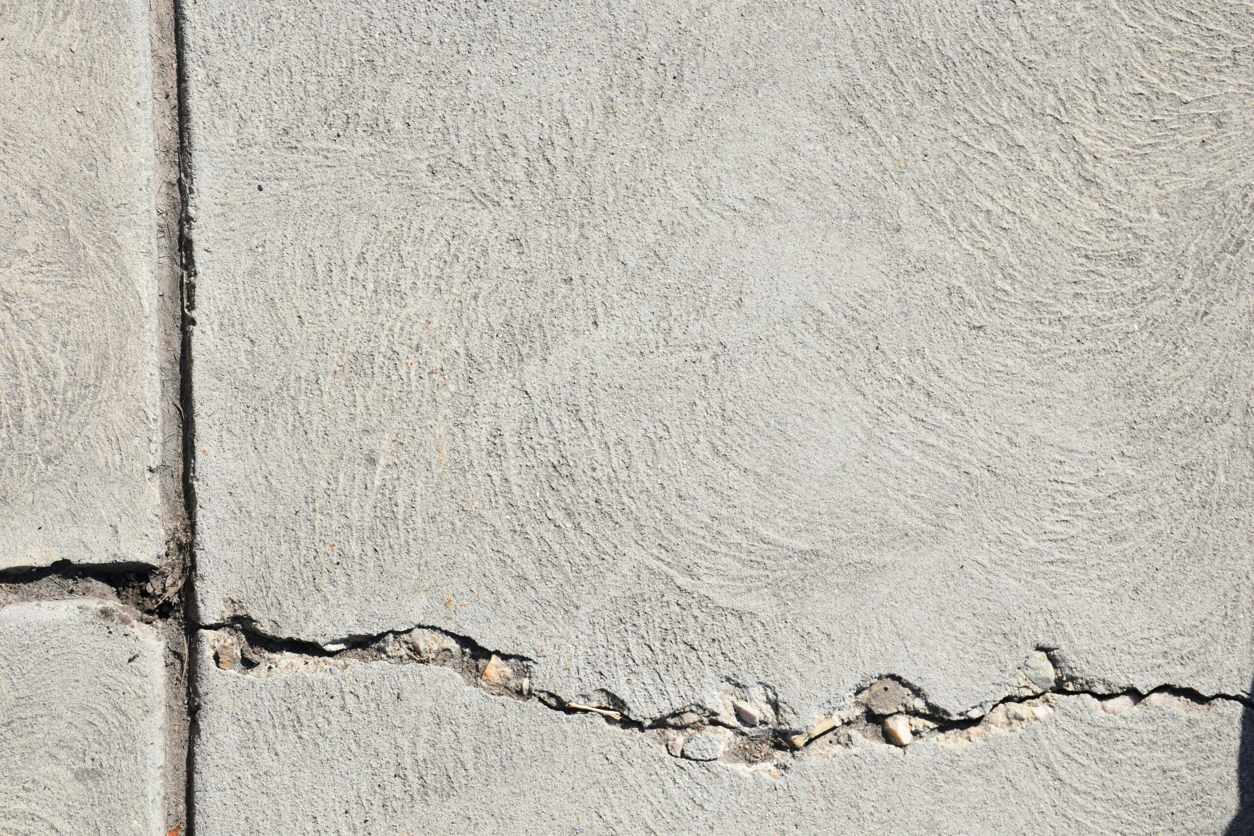 Close-up view of a cracked concrete surface with distinct textures in Logan, Utah.